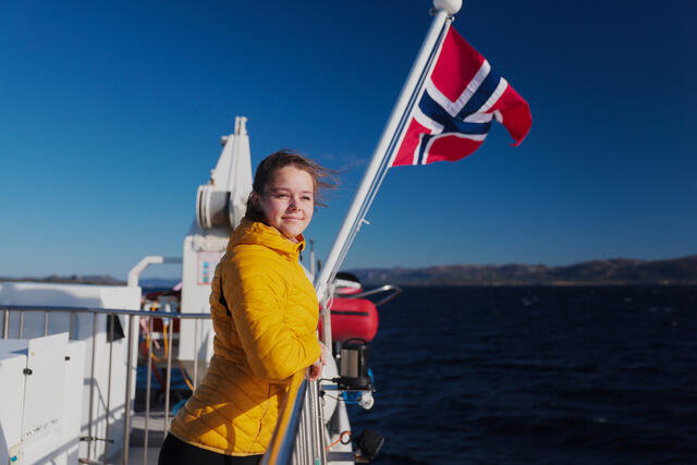Jente med flagg på hurtigbåt