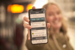 mobil holdes fram med AtB-appen på holdeplass