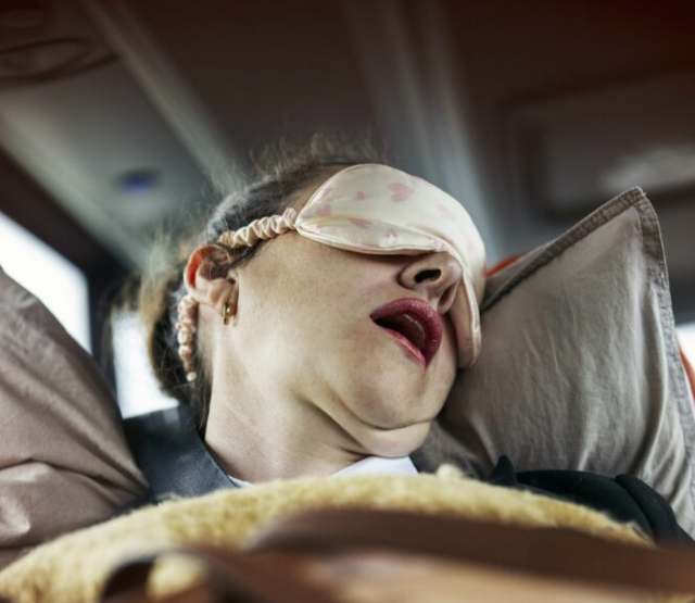 dame som sover med åpen munn på bussen