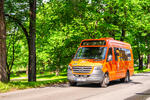 oransje minibuss atb bestill i grønne omgivelser i by