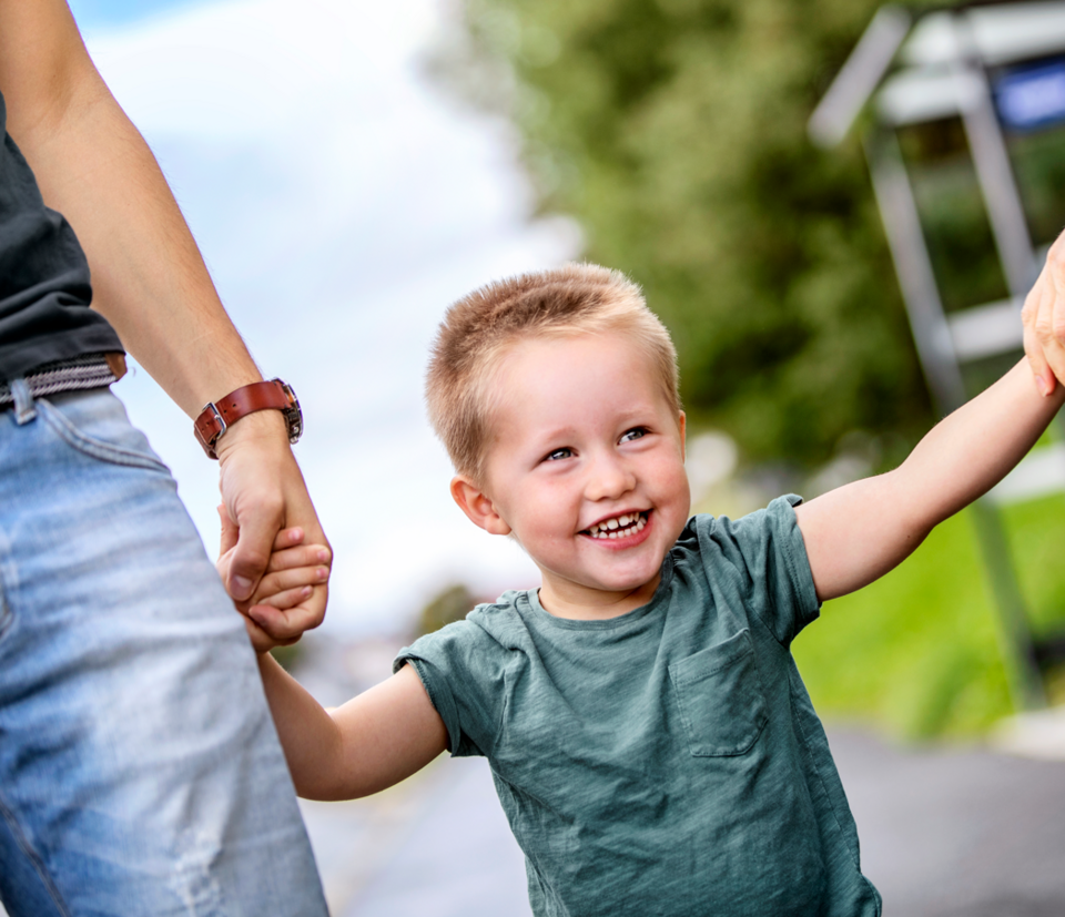 liten gutt som holde far i hånda etter å ha gått av bussen