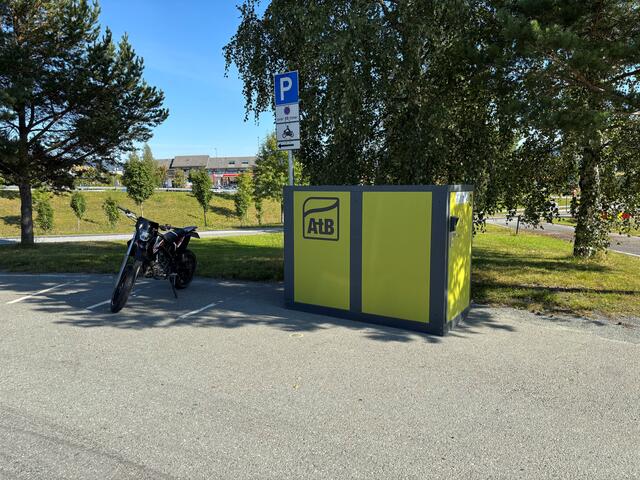 Grønn boks på grus med AtB-logo