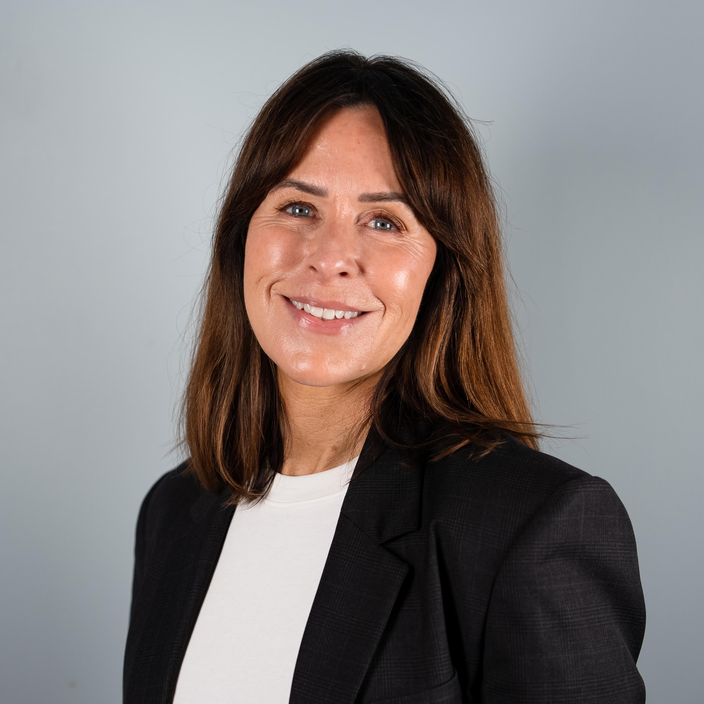 Smilende kvinne i sort blaser, Tine R. Hauan Nielsen