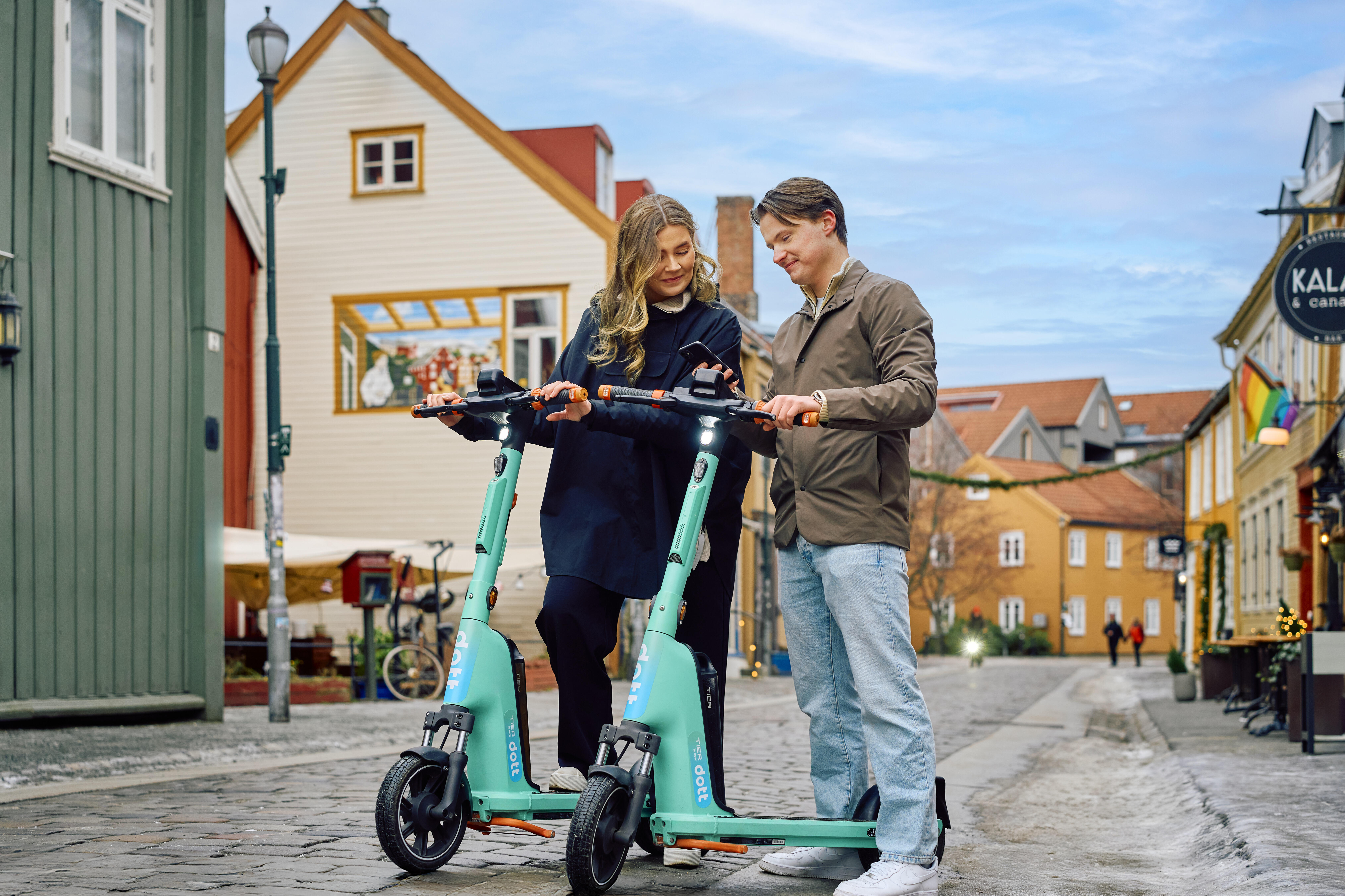To personer med elsparkesykkel fra Dott i hustungate