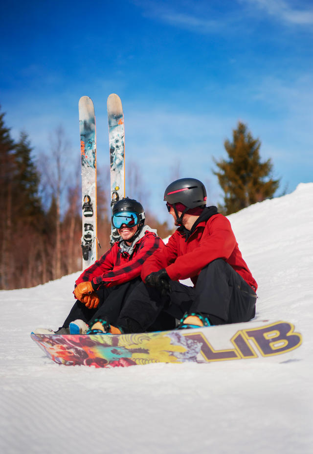 Gutter i skibakken med snøbrett og slalomski